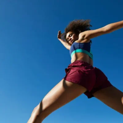 young woman exercising against clear sky young woman exercising against clear sky